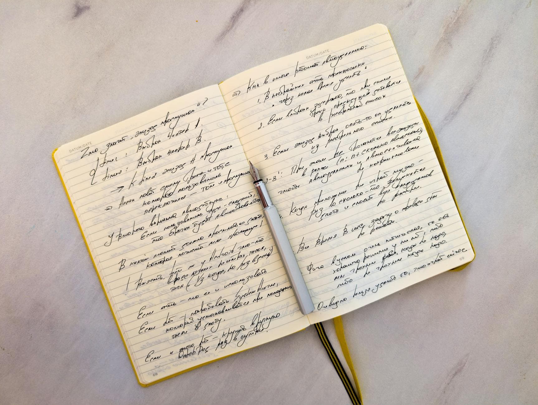 A hand writing tasting notes in a journal next to a glass of wine